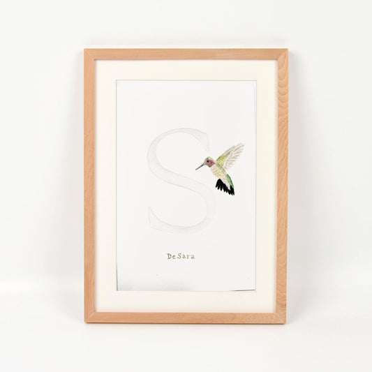 Inicial S con colibrí enmarcado en madera nativa
